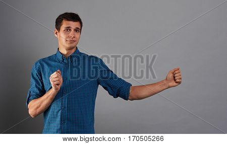 Hansome student with open hands for product or poster. Studio portrait of guy who holding something. Concept for insert page billboard.