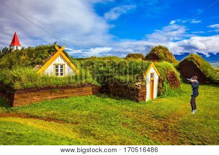 Ethnographic Museum-estate Glaumbaer, Iceland. The elderly woman photographed the old village. The concept of the historical and cultural tourism
