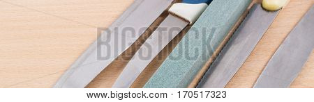 grindstone and blade kitchen knives on a wooden background, what we use every day in the kitchen