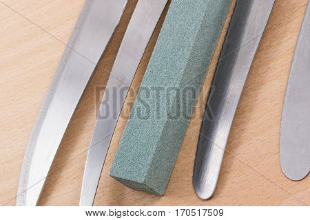 grindstone and blade kitchen knives on a wooden background, what we use every day in the kitchen