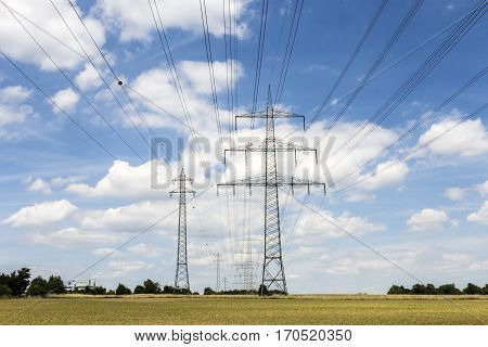 Electric Pylon On  Field Under Blue Sky