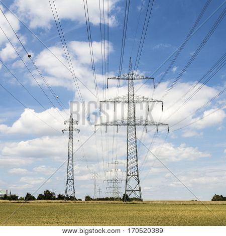 Electric Pylon On  Field Under Blue Sky