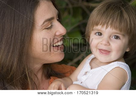 Loving mother and her daughter hugging outside.