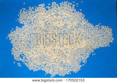 Basmati white uncooked rice on blue background. minimalism background isolated