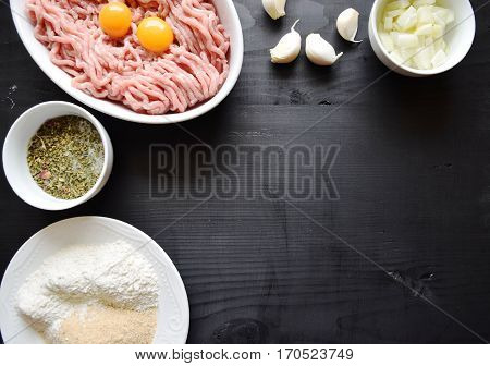Raw minced meat with seasonings on dark background. minced meat and ingredients on the table. horizontal view from above