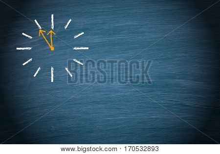 Clock on blue chalkboard background with copy space for individual text