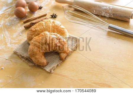 Close up shot of Croissant and bekery ingredients on wooden table with copy space