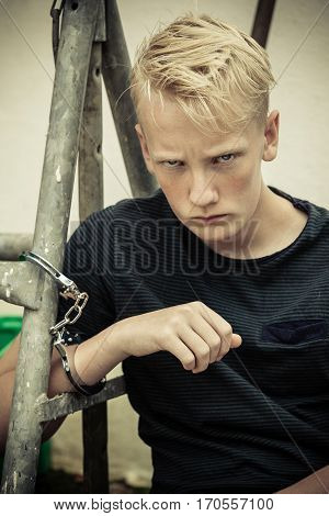 Rebellious Angry Teenage Boy In Handcuffs