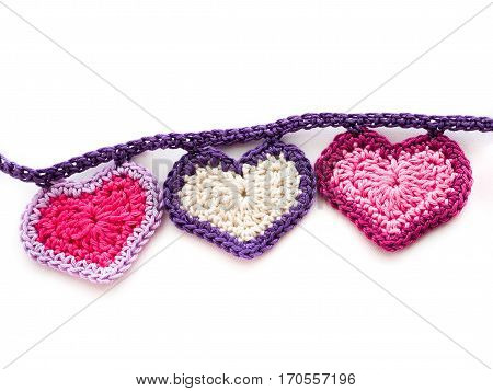 Three crocheted hearts with contrasting trim on a garland chain