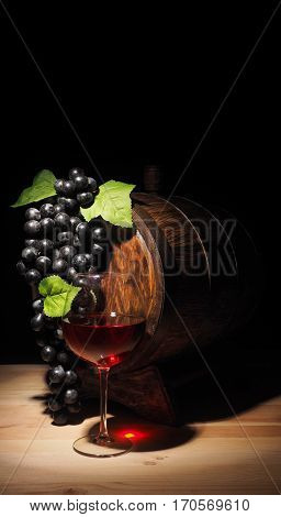 Glass Of Red Wine And Barrel On Wooden Table