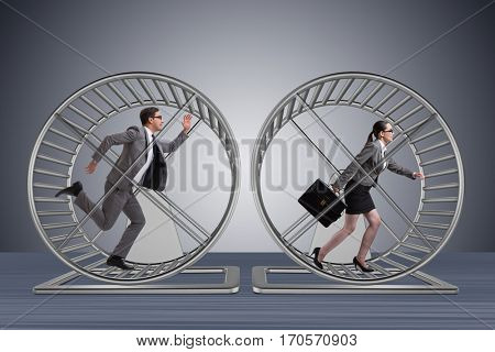 Business concept with pair running on hamster wheel