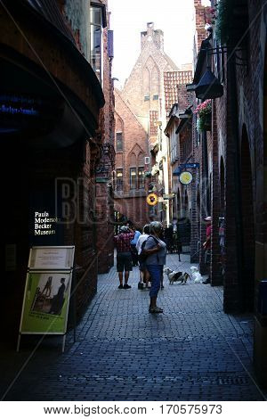 BREMEN, GERMANY - AUGUST 30: Pedestrians with dogs going through the narrow Boettcher Street near the Paula Modersohn-Becker Museum on August 30 2016 in Bremen.