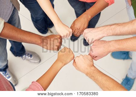 teamwork, friendship, international, gesture and people concept - group of hands making fist bump