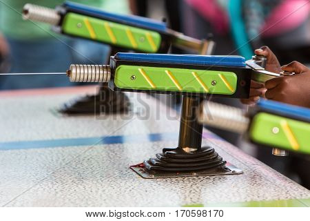 A water gun squirts a stream of water at a target in a carnival game.