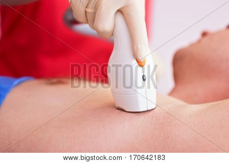 man receiving laser epilation at armpit on beauty center