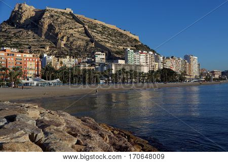 ALICANTE, SPAIN - JANUARY 8, 2013: View to Santa Barbara castle from the beach. Situated on the slopes of Mount Benacantil, the castle originated in IX century