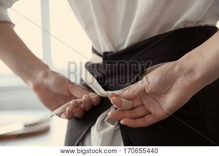 Woman  tying up her apron around the waist