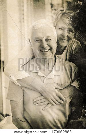 Grey background against portrait of happy senior couple at home
