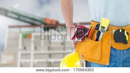 Mid section of construction man with tools at site