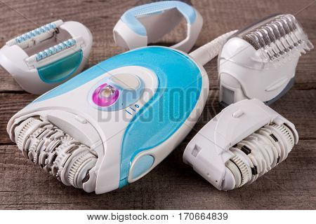 electric epilator on an old wooden background. Hair removal device