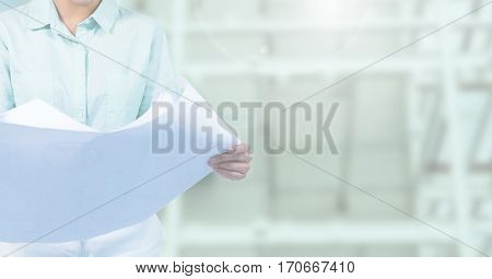Mid section of female architect holding blueprint