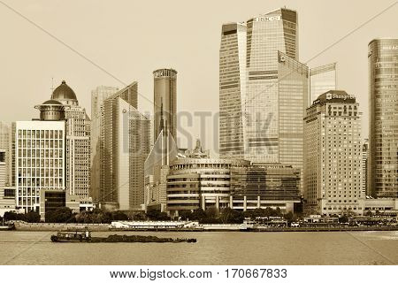 SHANGHAI CHINA - MARCH 25: Pudong district skyscrapers view from The Bund waterfront area on March 25 2016 in Shanghai China. Pudong is a district of Shanghai located east of the Huangpu River. Sepia toned photo