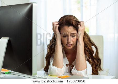 Frustrated sad businesswoman in front of computer at desk in office