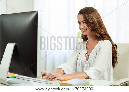 Happy businesswoman working at desk in office