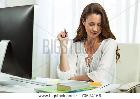 Happy businesswoman working at desk in office