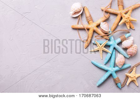 Border from marine items on grey tetured slate background. Sea objects. Selective focus. Place for text.