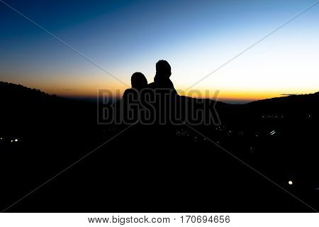 Silhouette of couple lover with sunset in the morning time.