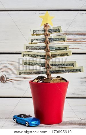 Pot with dollars and tpy car. Creative tips to save money.