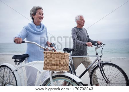 Senior couple having ride with their bike on the beach