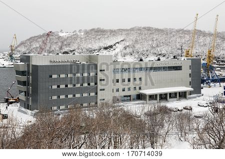 PETROPAVLOVSK-KAMCHATSKY CITY KAMCHATKA RUSSIA - JAN 12 2017: Winter view in snowy weather of new modern building of Marine Station in commercial sea port Petropavlovsk-Kamchatsky on Avacha Bay.