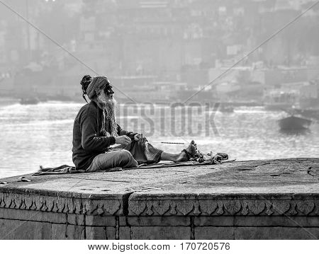 old man seeing time going by in a platform above the Gange river