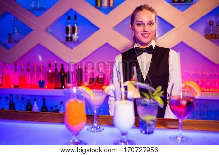 Portrait of breautiful smiling barmaid standing at nightclub