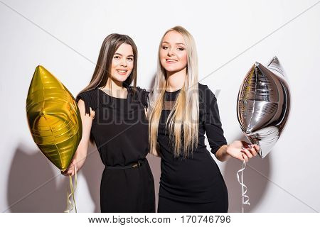 Two happy attractive yougn women having party over white background