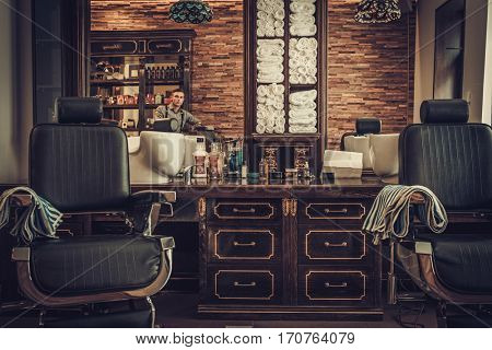 Professional hairstylist in barbershop interior
