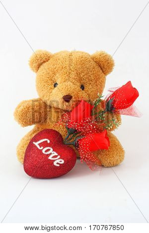 Brown teddy bears and red roses on a white background.
