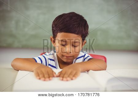 School boy memorizing the lesson in classroom at school