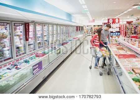 Serious couple doing grocery shopping together at grocery store