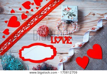 Hearts flowers ribbons on a wooden light background