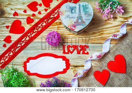 Hearts flowers ribbons on a wooden light background