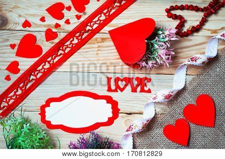 Hearts flowers ribbons on a wooden light background