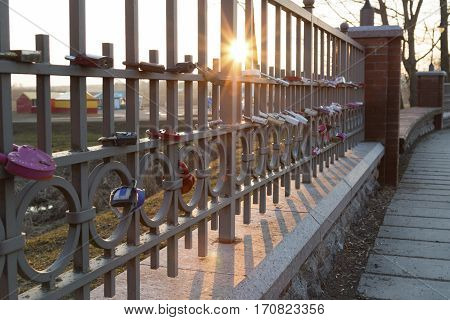 Belarus-February 27 2016 Fence hung with love locks love the wall winter sun rays locks newlywedsthe path of love