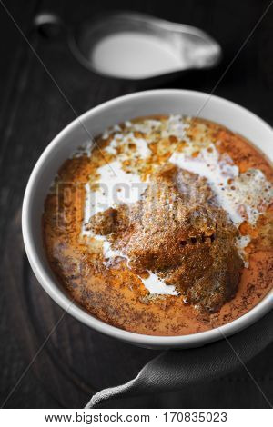 Butter chicken and gravy boat close up vertical