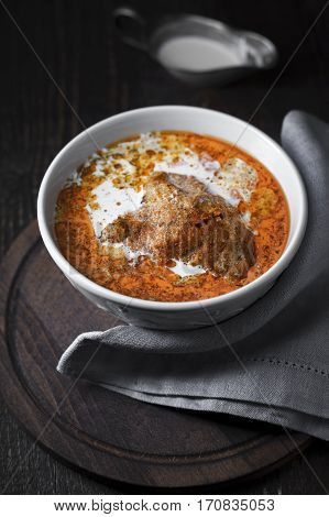Butter Bowl with chicken and gravy boat close on a napkin vertical