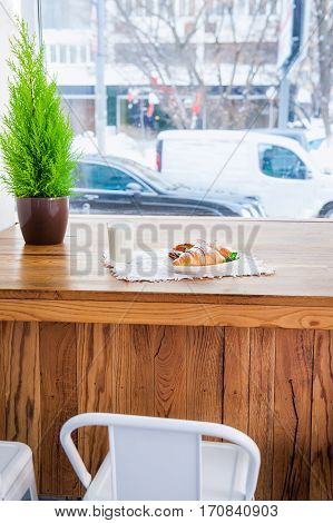 Cafe Table At The Window With View Of Active City And Served With A Breakfast Of Fresh Pastries And