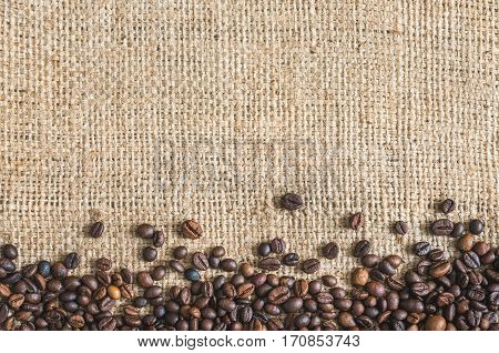 Roasted Coffee Beans on Burlap Background. Copy Space for Text.