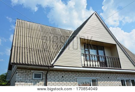 Asbestos roofing construction with gutter system. Gable and Valley type of roof construction.